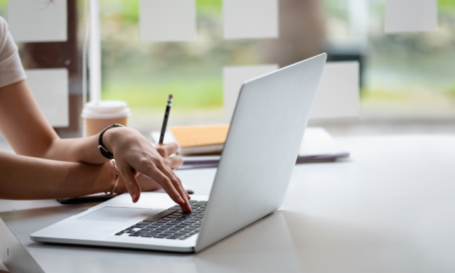 Woman's hands typing on a laptop.