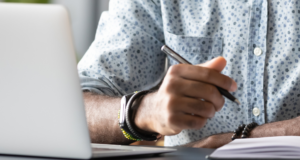 NOV 7 | Neurotrophic Keratitis in Focus – From Early Recognition to Strategic Intervention Close up of a man taking notes in front of a laptop.