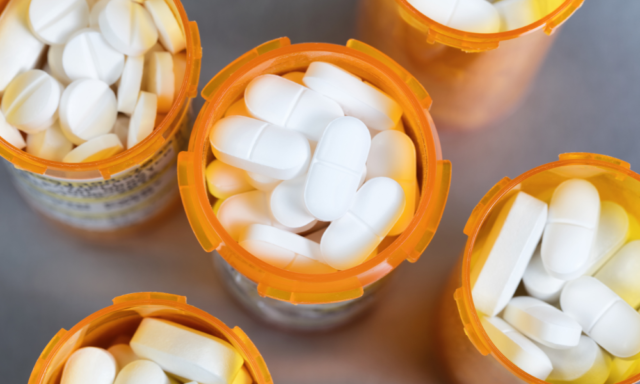 View from above of several open prescription pill bottles