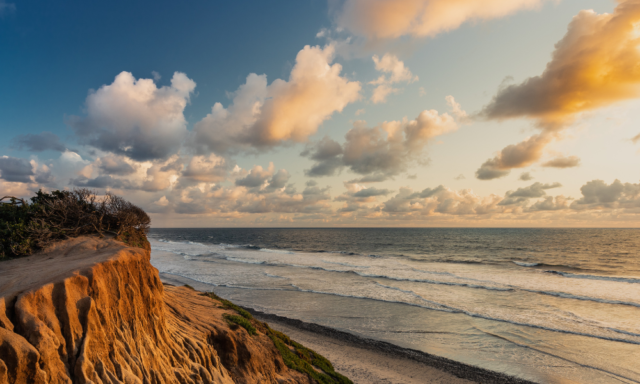 A beautiful sunset over the ocean with clouds in the sky in Carlsbad, CA.