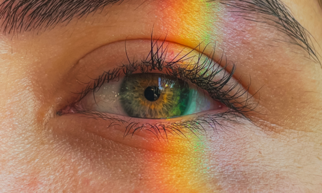 a strip of rainbow light on a woman's eye