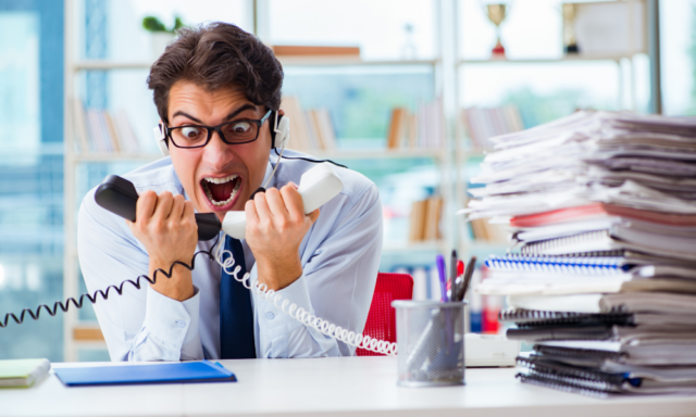 Frustrated office worker yelling into 2 phones at once