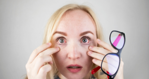 Buy-in Matters: 4 Ways To Help Your Patients Better Understand DED woman holding eyeglasses and showing her eye redness