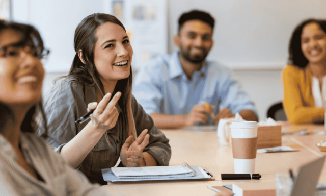 Staff members sitting around a table smiling