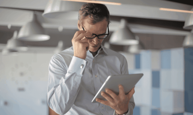 Man with glasses looking at a tablet