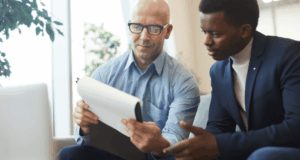 Be the Mentor You Wish You Had: Everything To Consider Before Allowing Shadowing Two guys, seated, looking at a document together