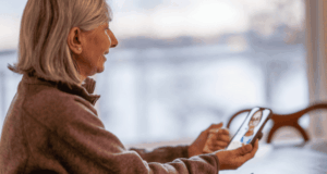 AOA Revises Telemedicine in Optometry Policy Woman using smartphone for a telehealth appointment