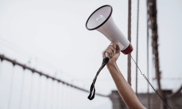 Outstretched arm holding a megaphone