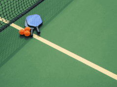 A Helpful New Resource on Sports Eye Safety Just Dropped overhead view of pickleball court with balls and rackets placed near the net