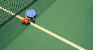 A Helpful New Resource on Sports Eye Safety Just Dropped overhead view of pickleball court with balls and rackets placed near the net