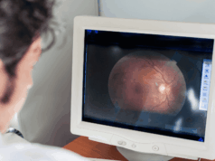 Top Oculomics Breakthroughs in 2025: What They Mean for Optometry optometrist looking at a retinal scan on a monitor