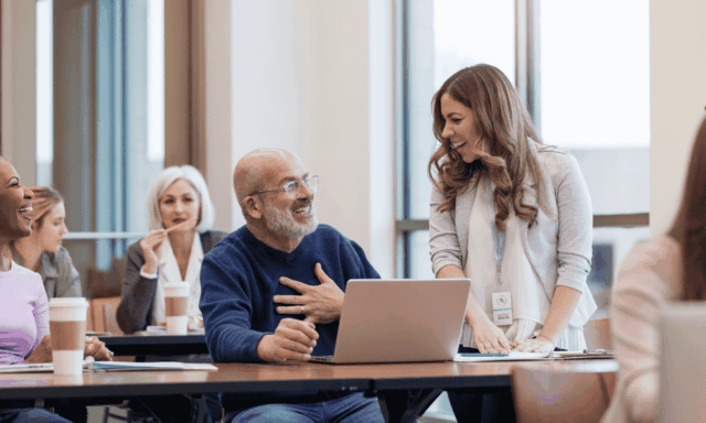 People sitting at tables at a conference presentation