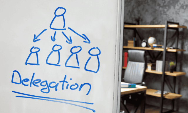 Whiteboard in an office that says "delegation"